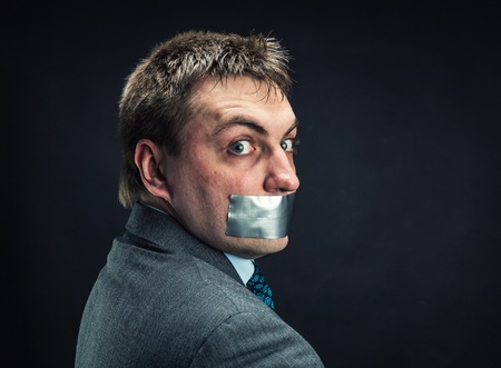 Man with mouth covered by masking tape ,studio shoot