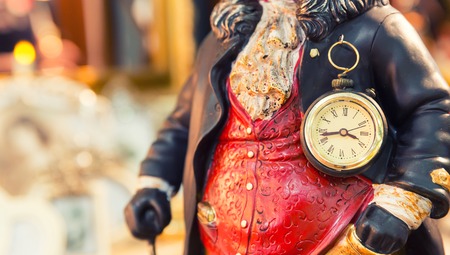 Ancient style clock on the statuette of man closeupの写真素材