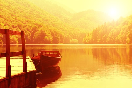 Wooden boat at pier on mountain lake in the morning. Biograd lake, Montenegroの写真素材