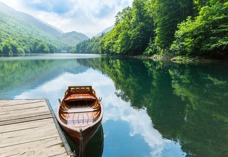 Wooden boat at pier on mountain lake. Biograd lake, Montenegroの写真素材