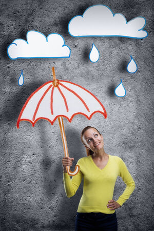 Smiling young woman with cartoon umbrellaの写真素材