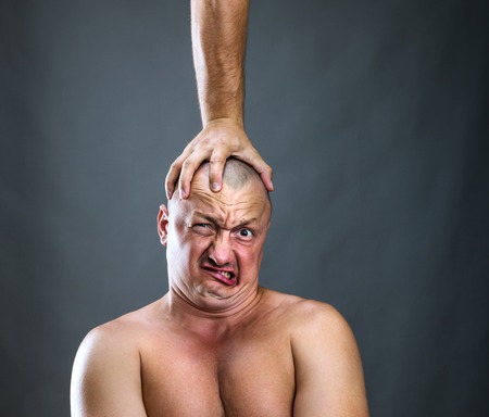 Hand is pressuring a manの写真素材