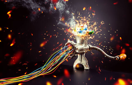 Retro mincing machine is grinding up colorful batteries to cablesの写真素材