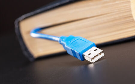 Blue usb cable sticks out from the bookの写真素材