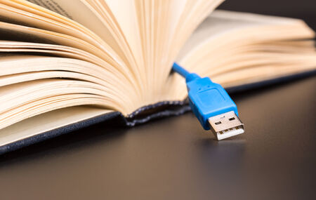 Blue usb cable sticks out from a bookの写真素材