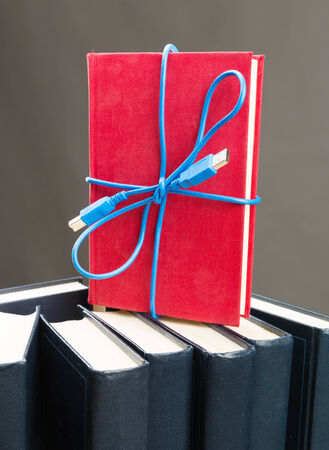 Blue ribbon from the usb cable on the standing bookの写真素材