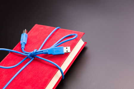 Blue ribbon from the usb cable on the bookの写真素材