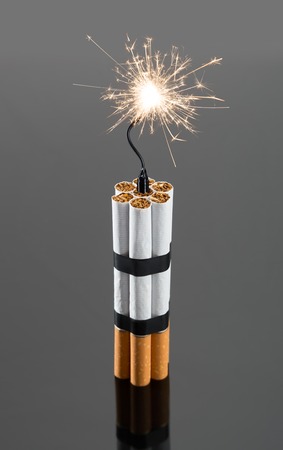 Explosives from cigarettes with sparks on gray backgroundの写真素材