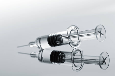 Medical syringe with injection on greyの写真素材