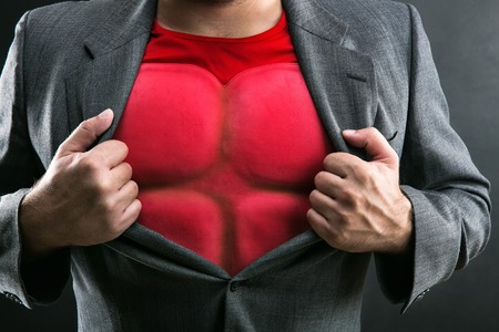 Man showing his flack jacket through his suit on greyの写真素材