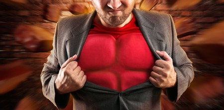 Man showing his flack jacket through his suit on brick wall backgroundの写真素材