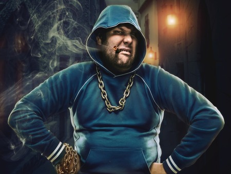 Angry man with a cigarette in the street at nightの写真素材