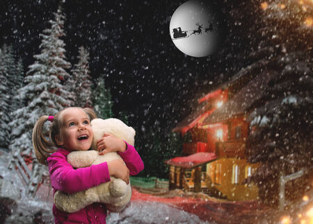 Cute girl at home holding toy bear outside in winterの写真素材