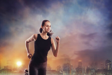 Young woman running outdoors in an evening city