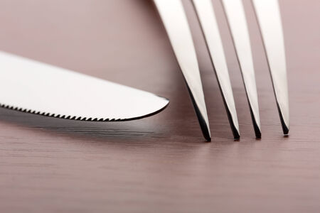 Macro of fork and knife on wooden background