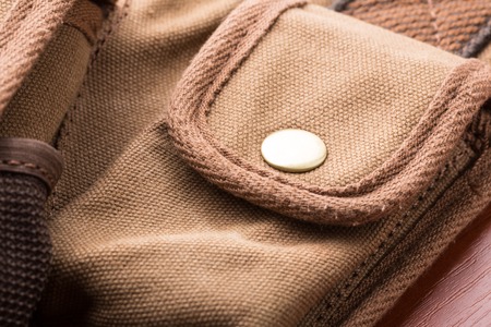 White button on small brown pocket