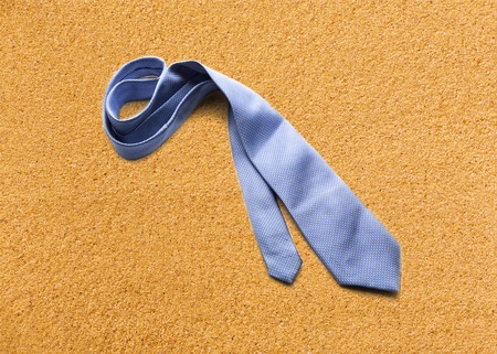 Blue necktie on sand at the beachの写真素材