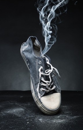Old gym-shoe from which the smoke proceedsの写真素材