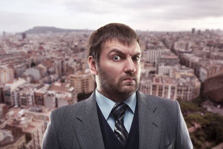 Astonished businessman against city backgroundの写真素材