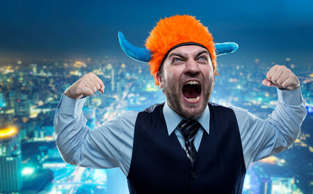 Odd businessman in party helmet shouting in the city
