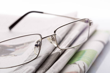 Macro of glasses lieing on the newspapersの写真素材