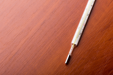 Thermometer on a wooden table with space