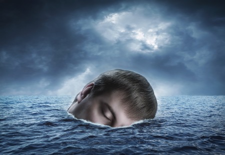 Drifting on the waves in the sea human headの写真素材