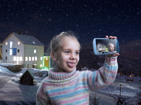 Little girl doing selfie in a winter eveningの写真素材