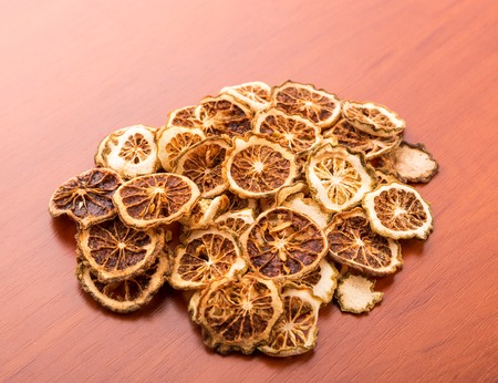 Heap of dried lime slices on wooden tableの写真素材