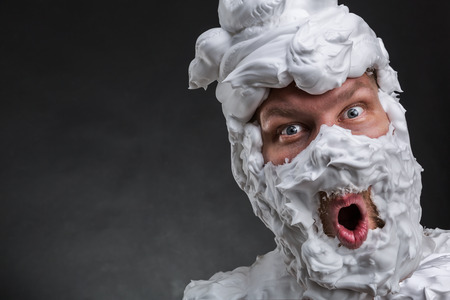 Surprised man with shaving foam on his faceの写真素材
