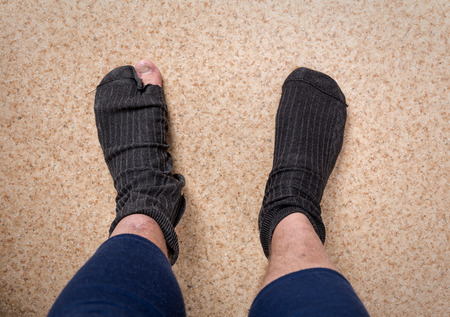 Male feet in old leaky socksの写真素材