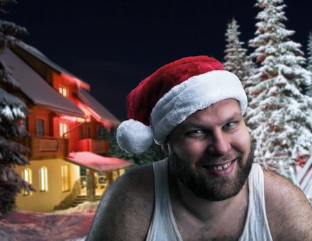 Smiling man in Santa Claus hat over winter night backgroundの写真素材