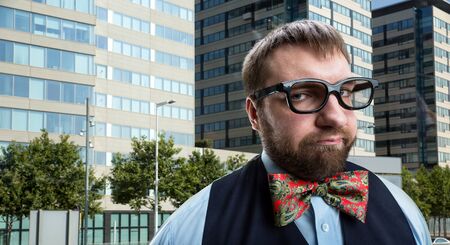 Nerd businessman in glasses against city backgroundの写真素材