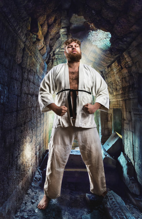 Serious karate fighter in white kimono in the temple hallの写真素材