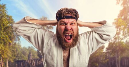 Aggressive karateka is tightening the black belt on his headの写真素材