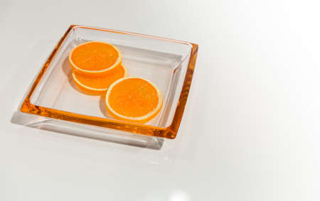 Tree pieces of an orange on a glass plateの写真素材