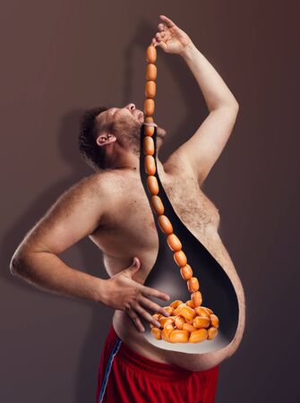 Bearded fat man eating big rope of sausagesの写真素材