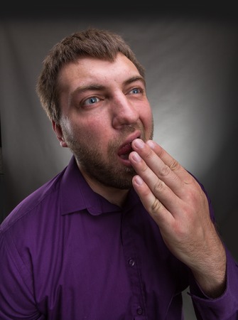 Adult man yawning over grey background