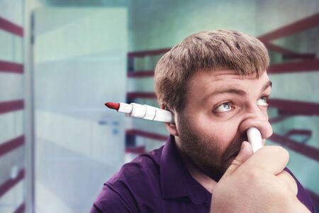 Strange bearded man with highlighter in the ear and in the noseの写真素材