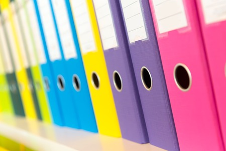 Colorful folders standing on the shelf in the officeの写真素材