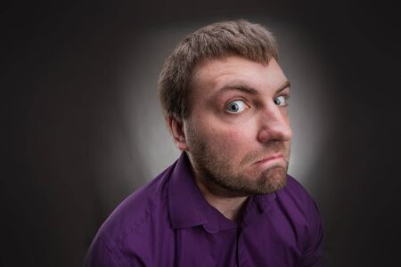 Frustrated inquisitive man over grey backgroundの写真素材