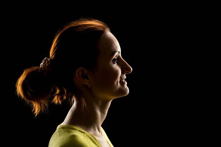 Side view of woman's face over blackの写真素材