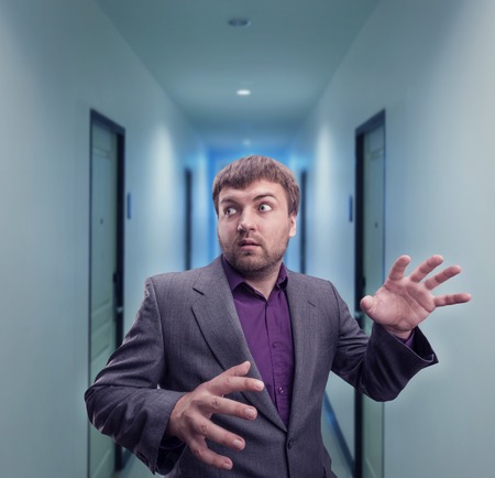 Scared businessman in the dark corridorの写真素材
