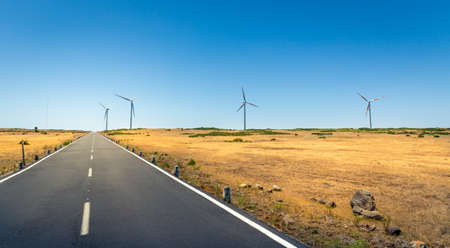 Road in the valley with windmills on each sideの写真素材