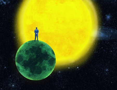 Businessman standing on the planet in front of the sunの写真素材