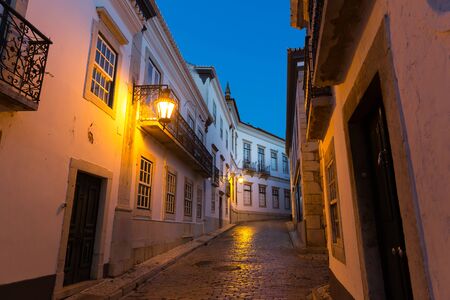 Narrow european street with paved road in the evening, Portugalの写真素材