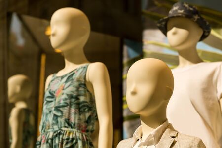 Female mannequins in dresses in th storefront