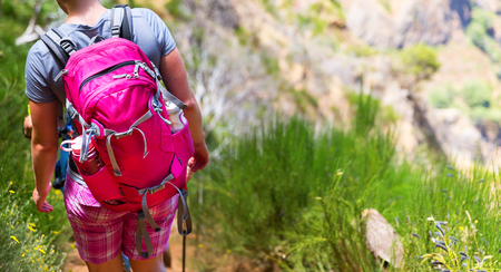 Woman with a pink backpack hiking in mountains, Portugal, Madeiraの写真素材
