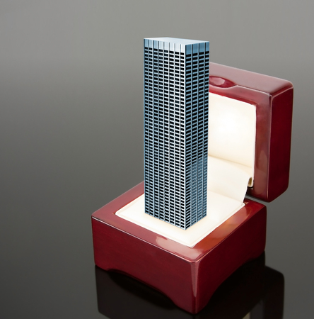 High office building in red jewelry box over grey backgroundの写真素材