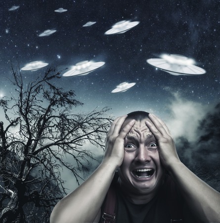 Scared by UFO man screaming at night in the forestの写真素材